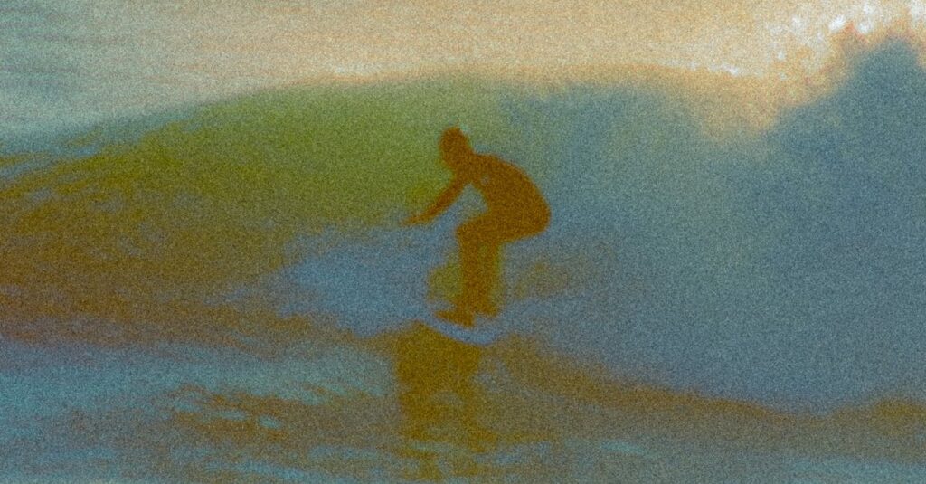 A surfer skillfully navigates a wave, showcasing the art of surfing at sea.