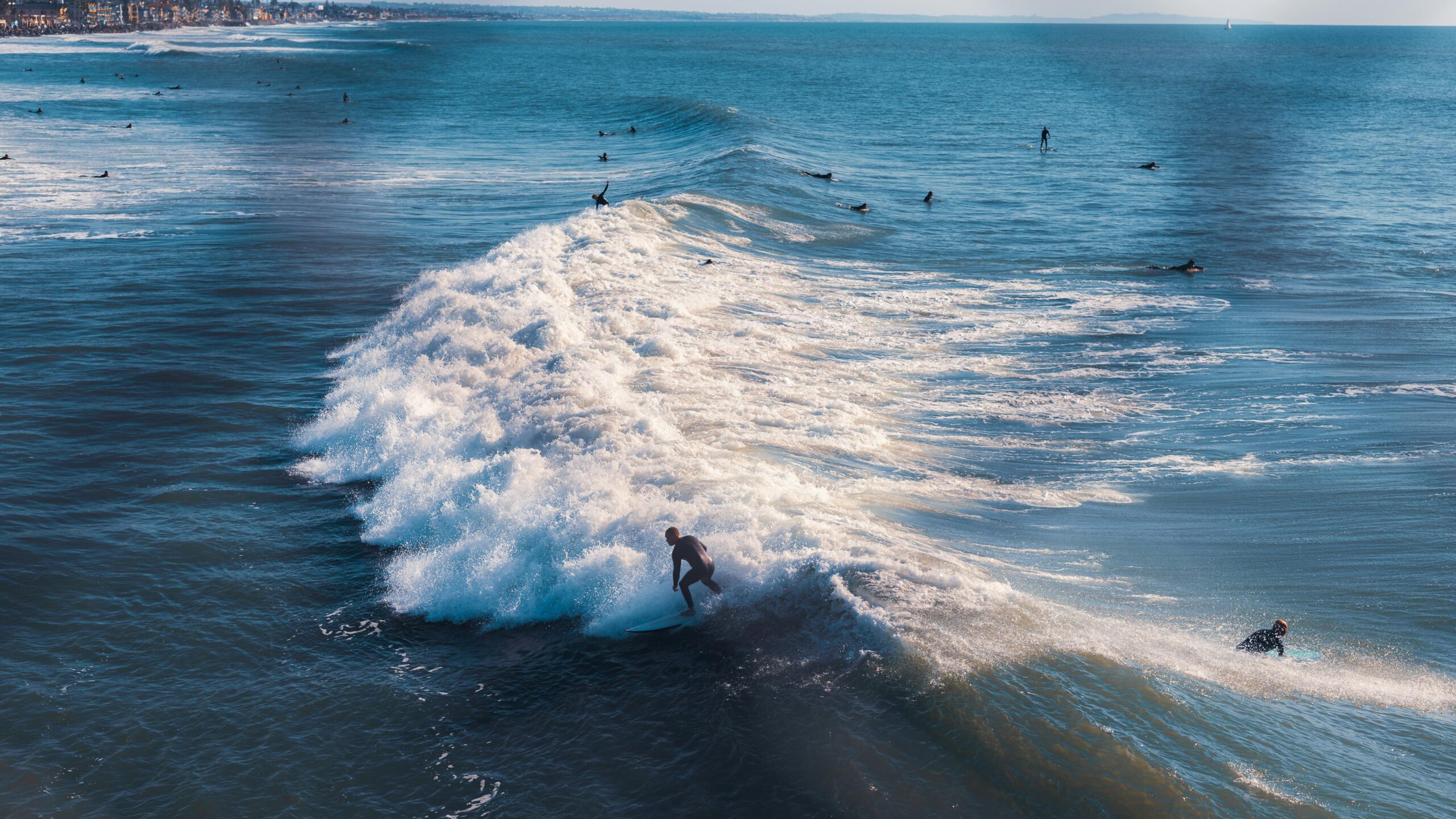 Surfers ride ocean waves, showcasing thrilling surfing adventure at a scenic beach location.
